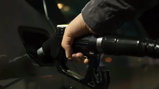Hånd fyller drivstoff på bil